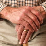 man with arthritis holding his opposite hand