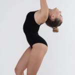 gymnast bending slight backwards with hands in the air